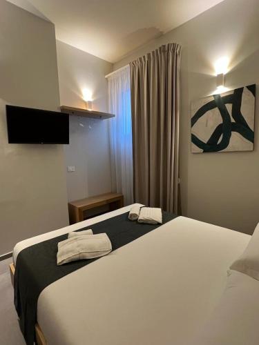 a bedroom with a large bed with two towels on it at Egusa73 Favignana in Favignana