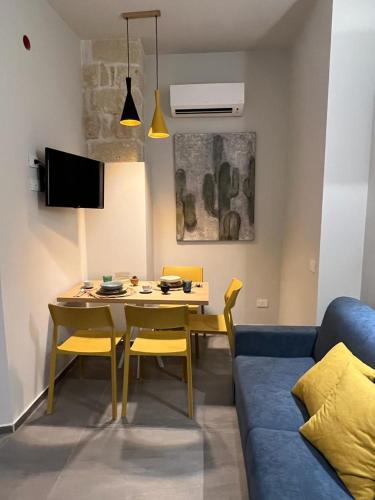 a living room with a table and chairs and a couch at Egusa73 Favignana in Favignana