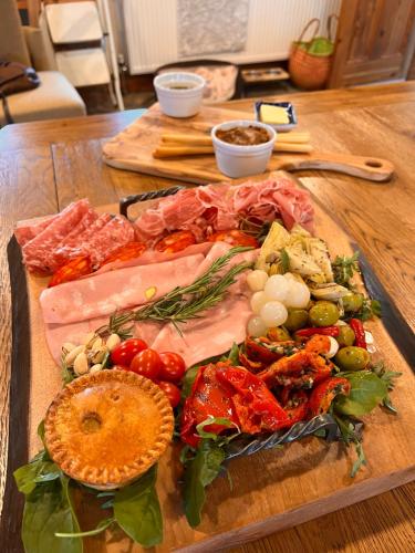 a cutting board with meats and vegetables on a table at Stunning location on Pendle Hill in Nelson