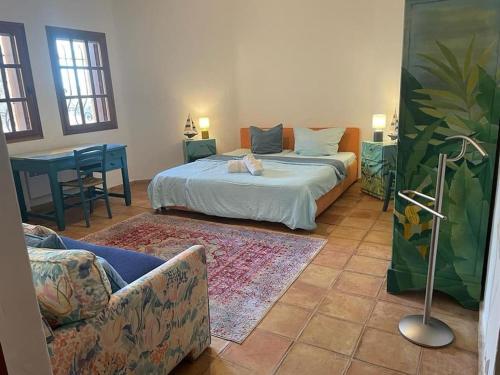 a bedroom with a bed and a couch and a table at Spacious Villa with Pool and Fireplace in Roquebrune-sur-Argens