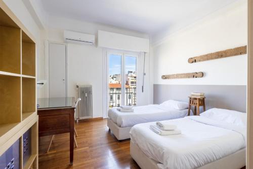 ein Hotelzimmer mit 2 Betten und einem Schreibtisch in der Unterkunft 3 bdr Apt Incredible Acropolis View in Athen
