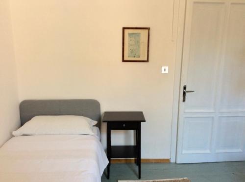 a bedroom with a bed and a table next to a door at Albergo Gargnano in Gargnano