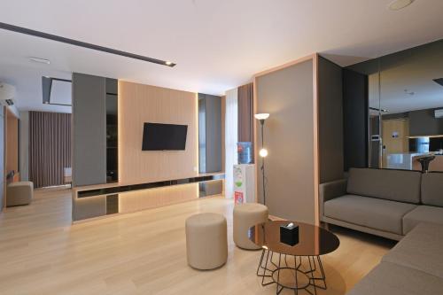 a living room with a couch and a table at Quest Prime Pemuda - Semarang in Semarang