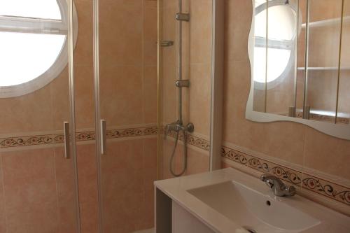 a bathroom with a shower and a sink and a mirror at Delfines II Solo Familias Serviplaya in Playa de Xeraco