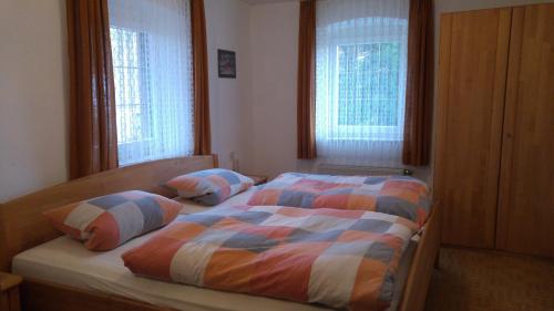 een slaapkamer met een bed en 2 ramen bij Gasthaus zum Goldenen Roß in Creglingen
