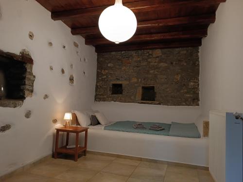 Casa di Pietra في Neápolis: غرفة نوم بسرير وجدار حجري