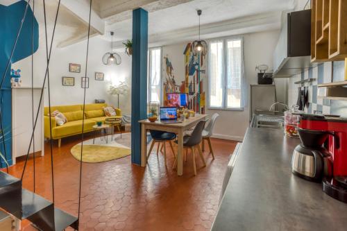 uma cozinha e sala de estar com uma mesa e um sofá amarelo em 26 nice em Nice