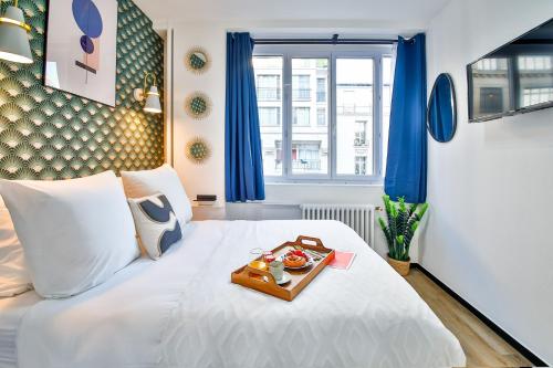 - un lit blanc avec un plateau de nourriture dans l'établissement Apartments WS Hôtel de Ville - Beaubourg, à Paris