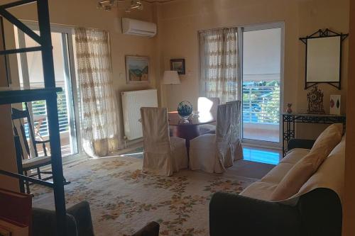 ein Wohnzimmer mit einem Sofa und einem Tisch in der Unterkunft Κεντρικό διαμέρισμα στη Γλυφάδα με θέα θάλασσα & ενοικίαση αυτοκινήτου in Athen