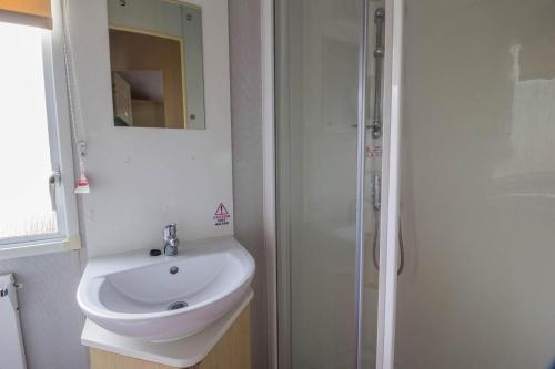 biała łazienka z umywalką i prysznicem w obiekcie Lovely 8 Berth Caravan For Hire At Broadland Sands In Suffolk Ref 20380bs w mieście Hopton on Sea