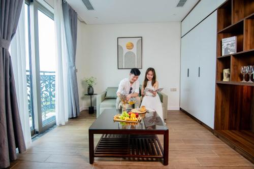 a bride and groom sitting in a living room at MK Riverside Apartment by Haviland in Danang