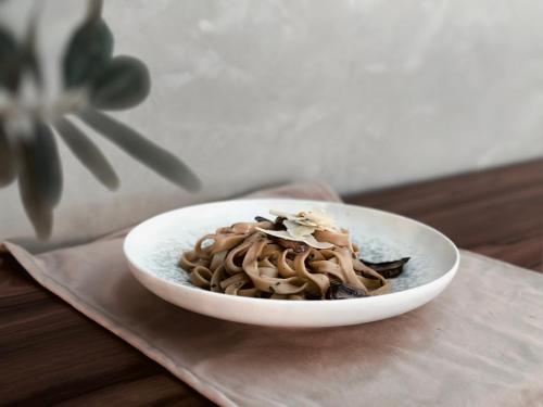 a bowl of pasta on a table with a plant at Louis Ledra Beach in Paphos City