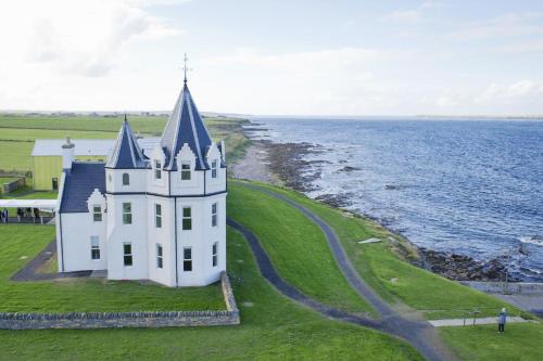 a castle on the shore of the ocean at Portgordon - 1 Bed Luxury Studio Apartment in Wick