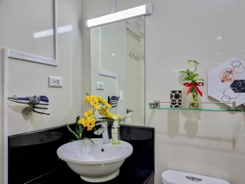 uma casa de banho com um lavatório branco e um espelho. em Condo Airport NAIA Terminal-3 One Palm Tree Villas em Manila