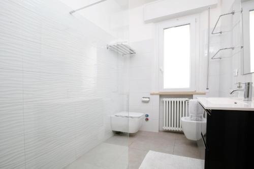 a white bathroom with a toilet and a sink at Appartamenti Diffusi di Villa Fiorita con accesso alle PISCINE della struttura principale in Cattolica