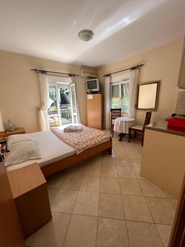 a bedroom with a large bed in a room with windows at Studio on the coast, with a view of the sunrise,free we-fi in Kotor