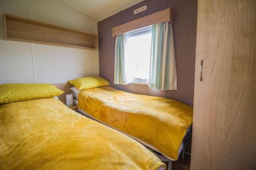 Un pat sau paturi într-o cameră la 6 Berth Caravan For Hire At Broadland Sands In Suffolk Ref 20077bs