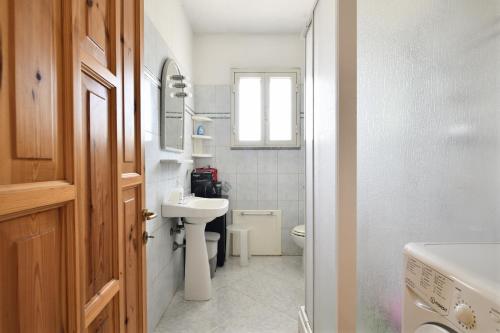 a small bathroom with a sink and a toilet at 3 - Casa con giardino Lotzorai - Sa Crai Apartments Sardinian Experience in Lotzorai