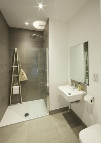 a bathroom with a shower and a sink and a toilet at Burghead - 1 Bed Luxury Studio Apartment in Wick