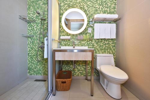 a bathroom with a toilet and a sink and a mirror at Fullon Poshtel Kenting in Kenting