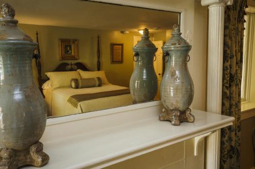 two vases sitting on a mantle in a bedroom at Eliza Thompson House, Historic Inns of Savannah Collection in Savannah