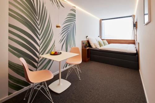 een kamer met een bed en een tafel en stoelen bij TIN INN l Erkelenz einfach gut - Das Hotel aus hochwertig ausgebauten Überseecontainern in Erkelenz