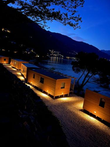 a row of small buildings with lights at night at Lakeview Cannobio Camping & Resort in Cannobio