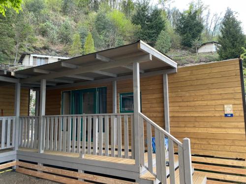 a wooden house with a porch and a roof at Lakeview Cannobio Camping & Resort in Cannobio