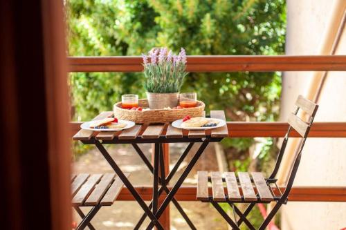 een tafel met 2 stoelen en eten op een balkon bij [Putzu Idu]1°FL. Modern apartment near the sea in Putzu Idu