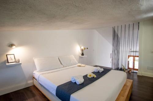 een slaapkamer met een groot wit bed en handdoeken bij [Putzu Idu]1°FL. Modern apartment near the sea in Putzu Idu