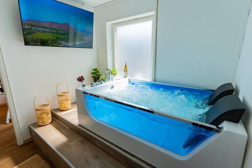 uma grande banheira azul numa casa de banho com uma janela em THE BIG MÜNSTER für bis zu 12, Whirlpool, Sauna, zentral, Tischfußball, Balkon, Gasgrill em Ulm