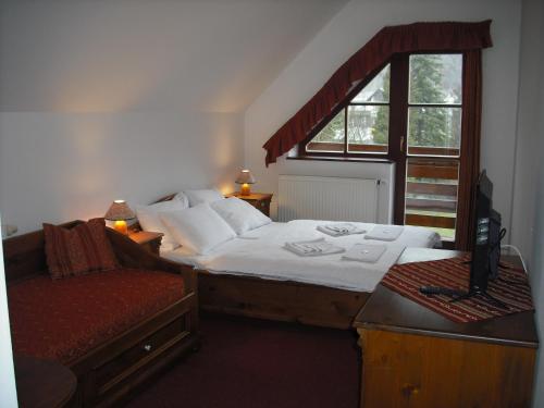 a bedroom with a bed and a window at Sport hotel POMI in Harrachov