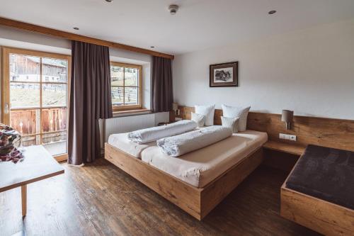 ein Schlafzimmer mit einem Bett und einem großen Fenster in der Unterkunft Riatschhof in Nauders