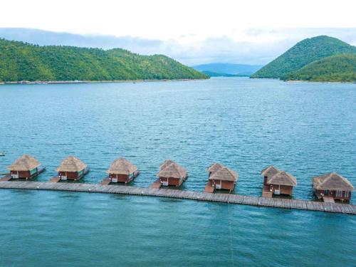 una fila de chozas en medio de un lago en Ruknam Resort, en Ban Hin Hak