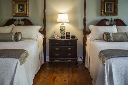 a bedroom with two beds and a lamp on a dresser at Eliza Thompson House, Historic Inns of Savannah Collection in Savannah