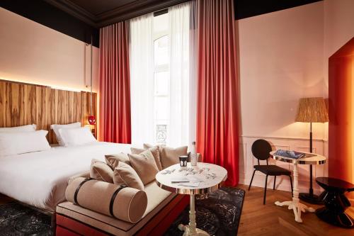 a hotel room with a bed and a couch and a table at Mama Shelter Rennes in Rennes