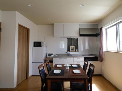a kitchen with a table and chairs in a room at 貸別荘 ウサギの郷 in Fujikawaguchiko