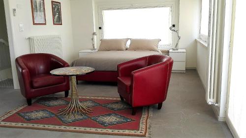 a bedroom with a bed and two chairs and a table at Residence "I Centralissimi Mamiblu' " in Vasto