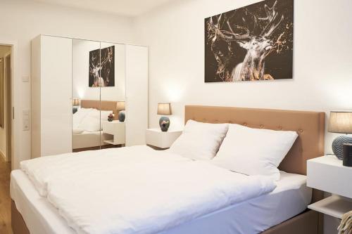 a bedroom with a large white bed and a mirror at Wohnen auf Zeit & Ferien in Wehr - Apartment Sand in Wehr