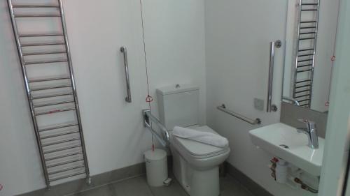 a white bathroom with a toilet and a sink at Buckie - 2 Bed Luxury Apartment in Wick
