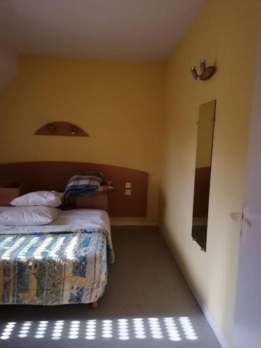 małą sypialnię z łóżkiem i lustrem w obiekcie La Peyrie T2 w mieście Bagnères-de-Bigorre