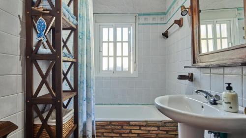 een badkamer met een bad en een wastafel bij Villa Maymonis Chiclana de la Frontera by Ruralidays in Chiclana de la Frontera