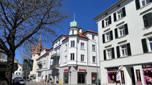 un bâtiment blanc avec une tour d'horloge dans une rue dans l'établissement Laura, à Äschach