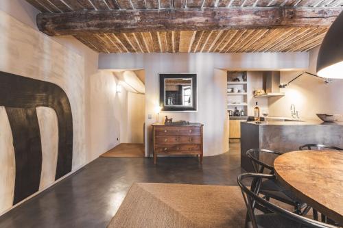 une salle à manger avec une table et une cuisine dans l'établissement Maison du PORTAIL NEUF à SAINT TROPEZ, à Saint-Tropez