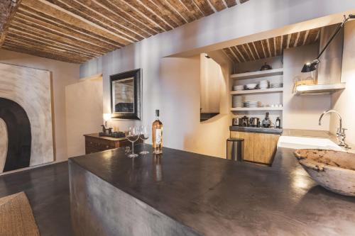 - une cuisine avec un grand comptoir et un évier dans l'établissement Maison du PORTAIL NEUF à SAINT TROPEZ, à Saint-Tropez