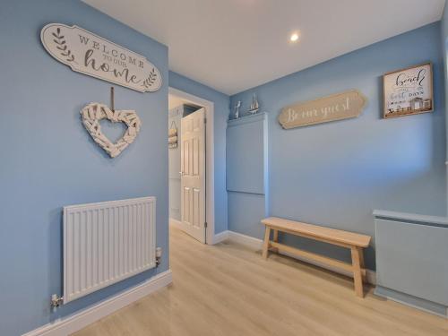 ブラックプールにあるDYSA Bentinck Houseの青い壁の客室で、ベンチと看板が備わります。