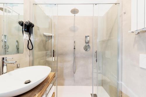 a bathroom with a glass shower with a sink at Acquamarina in Spello
