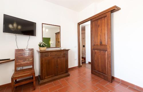 a room with a wooden door and a television on a wall at Acquamarina in Spello