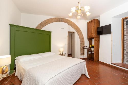a bedroom with a large bed with a green headboard at Acquamarina in Spello