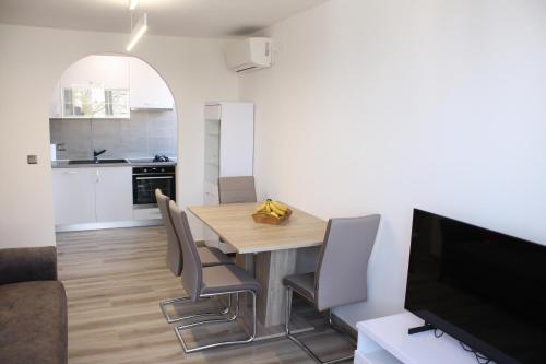 een keuken en eetkamer met een houten tafel en stoelen bij Apartment AmongUs in Dubrovnik